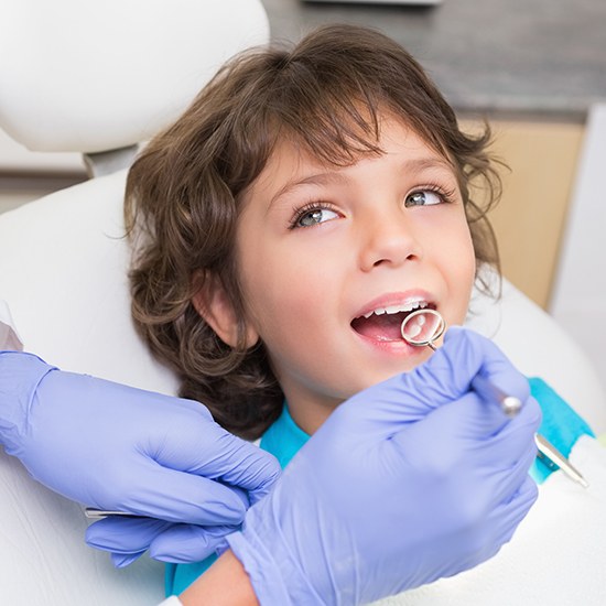 Dentist checking child's smile after fluoride treatment