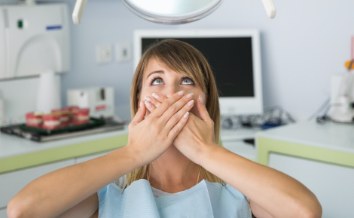 Fearful patient in need of sedation dentistry covering mouth