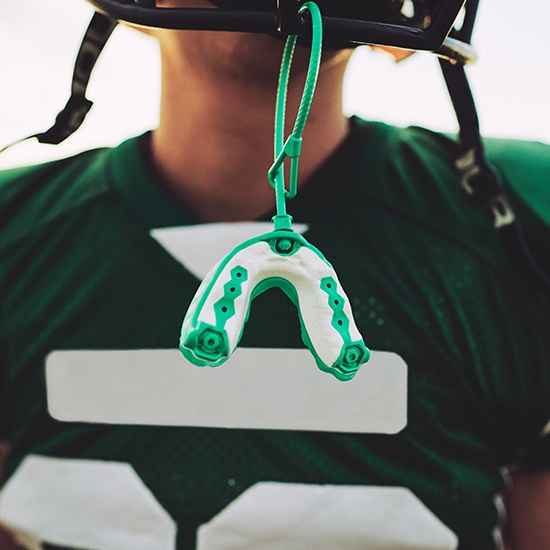 Green mouthguard hanging from football helmet