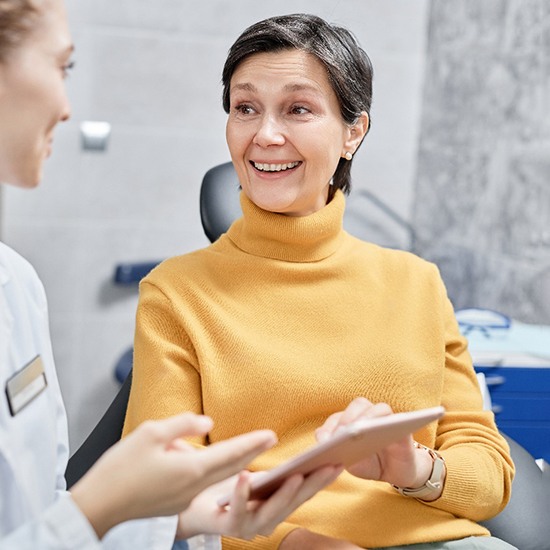 Woman learning cost of dental crowns in Arvada