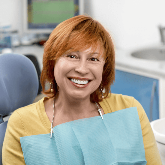 Woman sharing healthy smile after dental implant tooth replacement