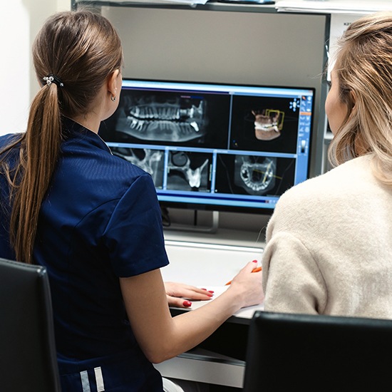 Dentist and team member looking at digital x-rays