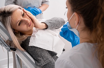 a patient holding her cheek due to toothache