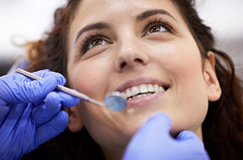 a patient smiling while undergoing a checkup in Arvada