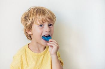 child wearing mouthguard to prevent dental emergencies in Arvada