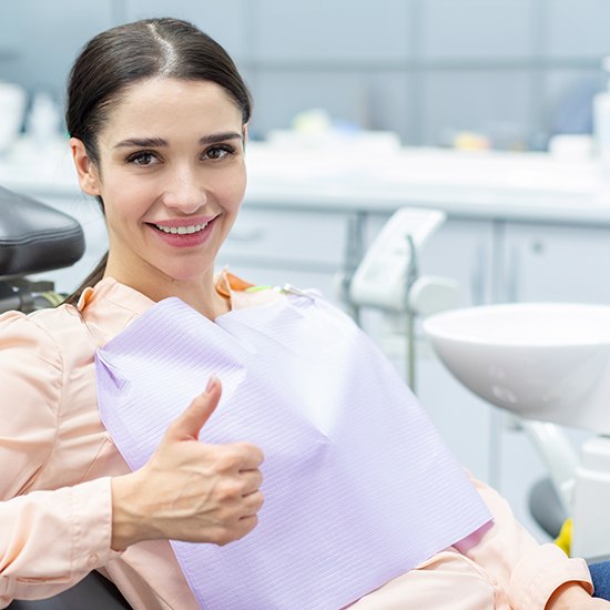 Female dental patient giving thumbs up