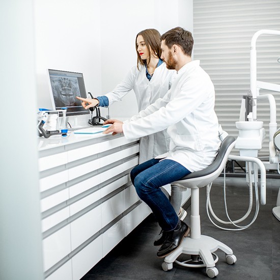 Dental team members next to computer discussing a patient’s X-Ray