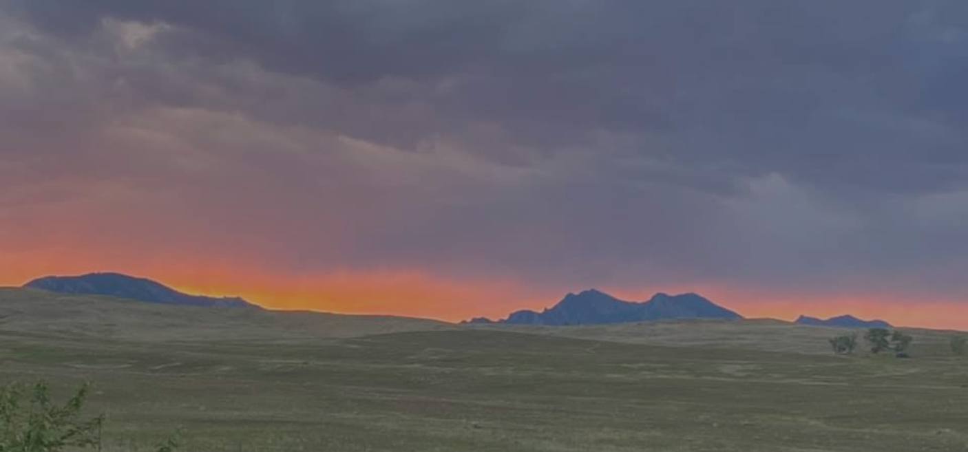 Field with mountains and clouds in the distance