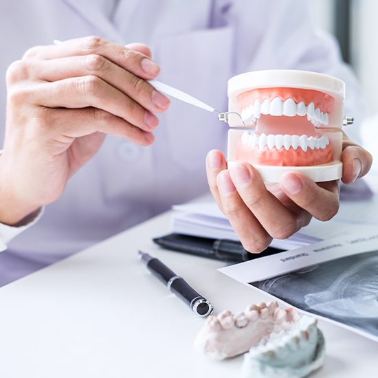 Dentist pointing to model smile