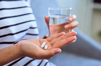 patient holding pills in hand 