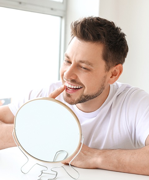 Man looking at smile in mirror