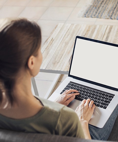 Woman using laptop for virtual smile consultation