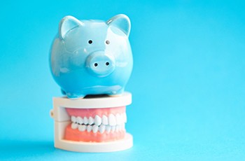 Piggy bank sitting on a model of teeth