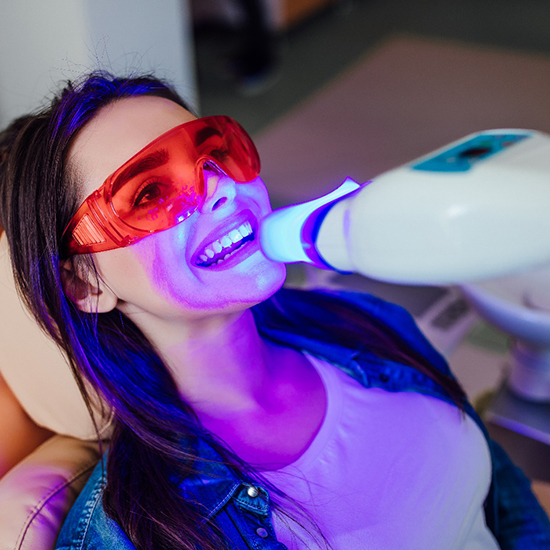 A closeup of a woman receiving teeth whitening treatment