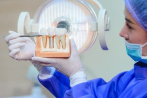 dentist showing a model of a dental implant