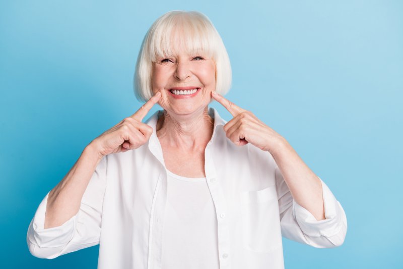 An older woman smiling with her cosmetic dentistry treatments