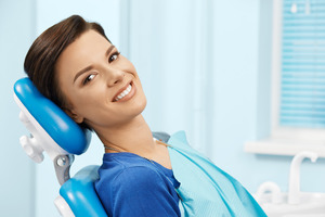 Woman with bright white grin looking to side and smiling