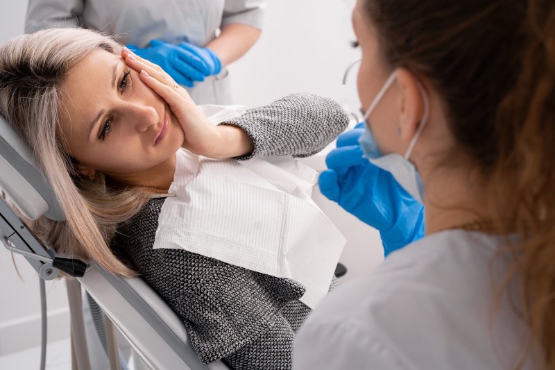 Lady looks to dentist with oral pain